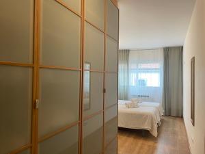 a bedroom with a bed and a large glass closet at ARZUAWAY in Arzúa
