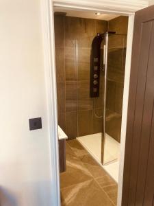 a shower with a glass door in a bathroom at 'Fairfield' at stayBOOM in Lancaster