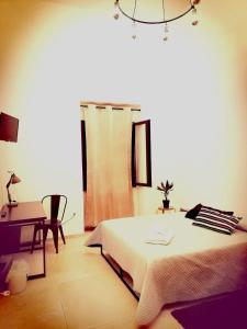 a bedroom with a bed and a desk and a window at ANDIRIVIENI☆LECCE ☆CASA VACANZE LECCE in Lecce