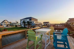a table and chairs on a deck with a view of the water at Come Stay - and Sail Away - at this Lovely Canal Home in Freeport