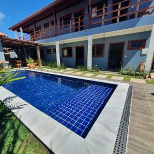 a swimming pool in front of a house at Pousada La Vita in São Miguel dos Milagres