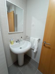 a bathroom with a white sink and a mirror at Palmeiro in Jove