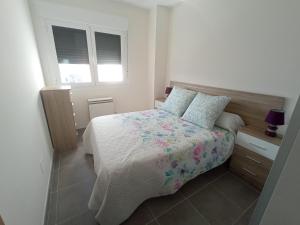 a bedroom with a bed with a floral bedspread and pillows at Palmeiro in Jove