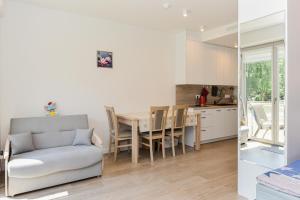 a kitchen and dining room with a table and a couch at White Forest in Juodkrantė