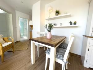 una cucina e una sala da pranzo con tavolo e sedie in legno di Haus-Kirsten-Fewo-Nr-5 a Cuxhaven