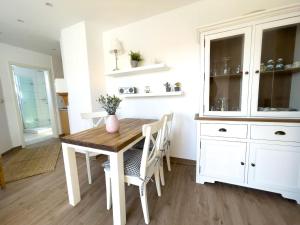 una cucina con tavolo in legno e armadietti bianchi di Haus-Kirsten-Fewo-Nr-5 a Cuxhaven