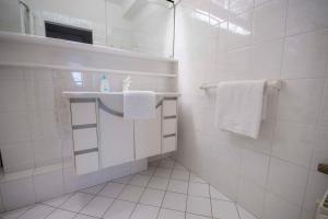 a white bathroom with white towels and a sink at Frische-Brise-10-01 in Cuxhaven +6 photos