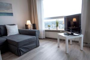 a living room with a couch and a tv and a table at Frische-Brise-10-01 in Cuxhaven