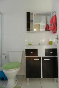 a bathroom with a toilet and a sink and a mirror at Sobrado completo em Caxias do Sul in Caxias do Sul