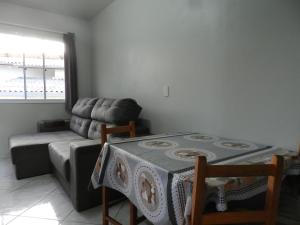 ein Wohnzimmer mit einem Tisch und einem Sofa in der Unterkunft Sobrado completo em Caxias do Sul in Caxias do Sul
