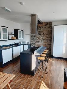 a kitchen with a black island and wooden floors at Voyage Hostel - Rooms with Shared Kitchen in Douglas