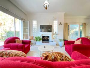 a living room with red furniture and a fireplace at 4 Bedroom Deluxe Villa with Mountain and Sea View in Kérynia