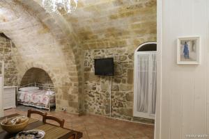 een kamer met een bed en een tv aan een bakstenen muur bij Terra e Marte casa vacanza in Bari