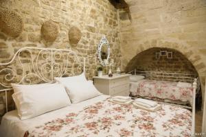 een slaapkamer met een bed en een stenen muur bij Terra e Marte casa vacanza in Bari