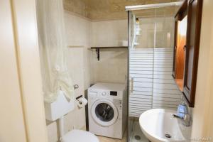 een kleine badkamer met een wasmachine en een wastafel bij Terra e Marte casa vacanza in Bari +14 foto's