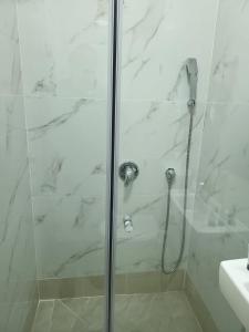 a shower with a glass door next to a sink at J-MOTEL in Jerusalem