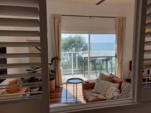 a living room with a couch and a view of the ocean at Saltwater Apartments in Lake Cathie