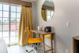 a desk and chair in a room with a mirror at Days Inn by Wyndham Santa Monica/Los Angeles in Los Angeles