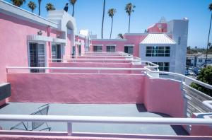 a group of pink and white buildings with palm trees at Days Inn by Wyndham Santa Monica in Los Angeles