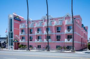 um edifício cor-de-rosa ao lado de uma rua em Days Inn by Wyndham Santa Monica em Los Angeles