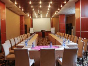 a conference room with tables and chairs and a whiteboard at Jupiter International Hotel - Bole in Addis Ababa