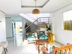 a living room with two chairs and a staircase at Aconchego dos Netos 2 - PRAIA DOS 3 COQUEIROS in Marau