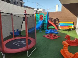 a playground with a slide and a swing set at Apartamento em Ubatuba in Ubatuba