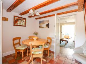 a dining room with a wooden table and chairs at Cameron's Cottage in Swaffham