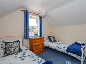 1 dormitorio con 2 camas y ventana en Cameron's Cottage en Swaffham