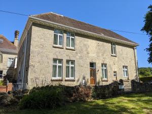 una antigua casa de piedra con un patio en Shanklin Manor en Shanklin