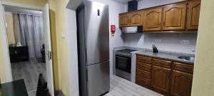 una cucina con frigorifero in acciaio inossidabile e mobili in legno di RUFIESCA a Torre de Moncorvo