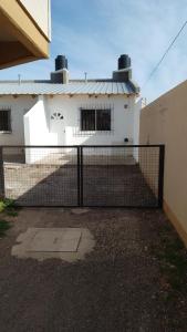 une clôture devant un bâtiment blanc dans l'établissement Alquiler por día Choele Choel 3, à Choele Choel