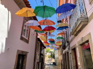 a bunch of colorful umbrellas hanging from a building at RUFIESCA in Torre de Moncorvo