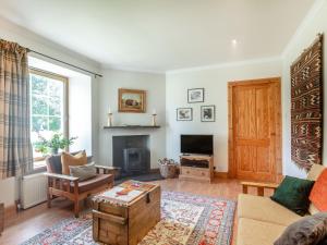 a living room with a couch and a tv at The Old Laundry in Grantown on Spey