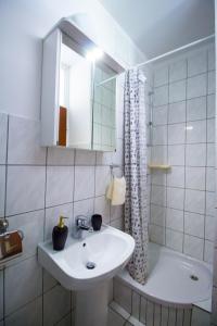 uma casa de banho com um lavatório, um espelho e uma banheira em Apartments by the sea Maslinica, Solta - 776 em Grohote