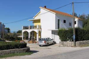 um carro estacionado em frente a uma casa branca em Apartments with a parking space Privlaka, Zadar - 667 em Privlaka