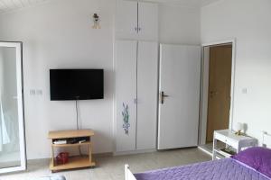 a bedroom with white cabinets and a tv on a wall at Studio Mimice 656b in Mimice