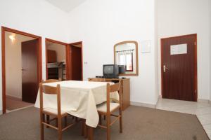 - une salle à manger avec une table, des chaises et un miroir dans l'établissement Apartments by the sea Pisak, Omis - 658, à Mimice