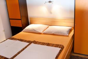 - une chambre avec un lit et 2 oreillers blancs dans l'établissement Apartments by the sea Pisak, Omis - 658, à Mimice