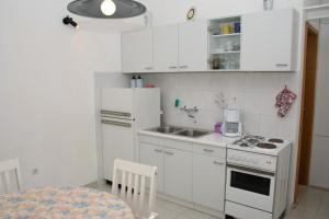 a kitchen with white cabinets and a white stove top oven at Apartments with a parking space Postira, Brac - 700 in Postira