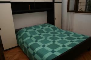 a green and white checkered bed in a room at Apartments with a parking space Postira, Brac - 700 in Postira