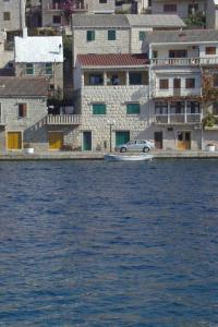 a car is parked next to a body of water at Apartments by the sea Povlja, Brac - 710 in Povlja