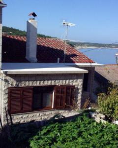 a building with a window on top of a roof at Apartments by the sea Povlja, Brac - 710 in Povlja