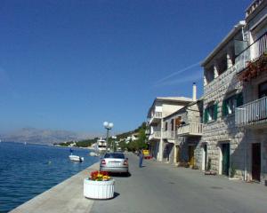 a car parked on a street next to a body of water at Apartments by the sea Povlja, Brac - 710 in Povlja