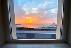 a window with a view of a sunset at Entire penthouse apartment with sea views Portrush in Portrush