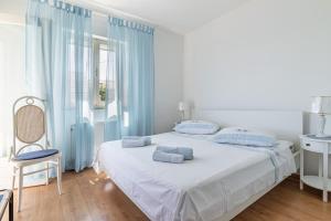 a white bedroom with a bed and a window at Apartments by the sea Puntinak, Brac - 718 in Selca
