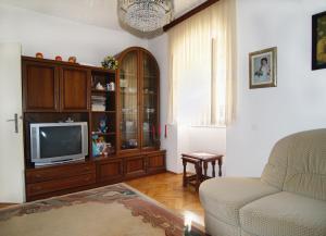 a living room with a couch and a tv at Apartments by the sea Sutivan, Brac - 719 in Sutivan