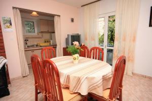 a dining room table with a vase of flowers on it at Apartments with a parking space Mirca, Brac - 728 in Mirce