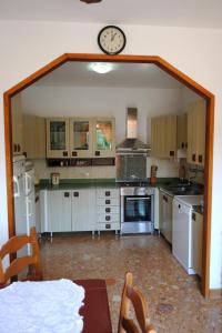 a large kitchen with a clock on the wall at Apartments by the sea Milna, Brac - 733 in Milna