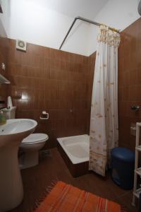 a bathroom with a toilet and a tub and a sink at Apartments by the sea Postira, Brac - 740 in Postira
